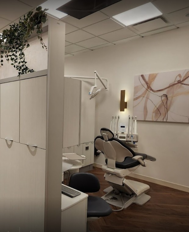 Inside My Dentist Vancouver: an open treatment bay with wall art, trailing plants and a wood floor